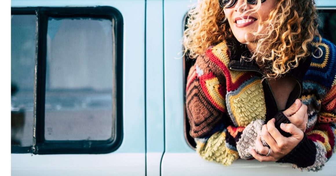 Smiling woman in colorful sweater.
