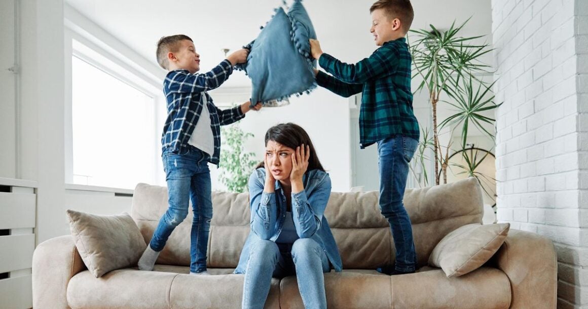 Children playfully fighting with pillows.